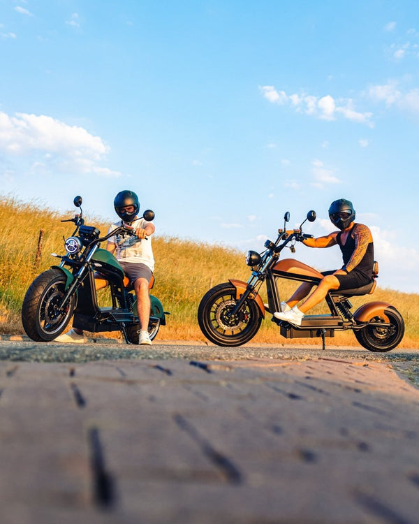 Zwei E-Chopper HL 6.0 Phantom auf Landstraße bei Sonnenuntergang – Lifestyle-Actionbild in Fahrt mit 45 km/h